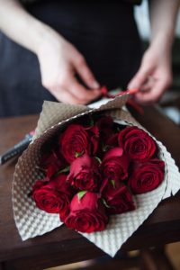 赤いバラの花束を作っている手